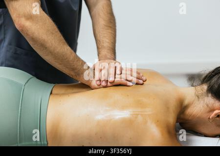 Terapeuta professionista che esegue un massaggio sportivo dei tessuti profondi Foto Stock