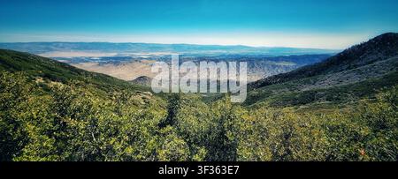 Veduta panoramica di una vasta valle desertica incorniciata dalle pendici delle montagne Foto Stock