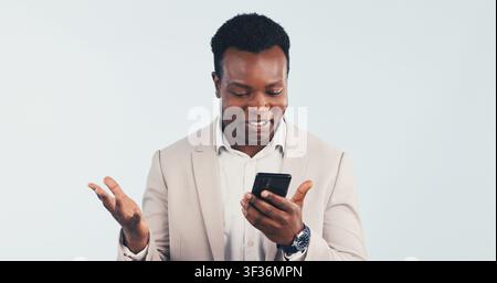 Uomo d'affari, sorpresa e sorriso in studio con telefono, legge un'e-mail o buone notizie per una proposta di budget. Felice, uomo nero e shock con la tecnologia, testo Foto Stock