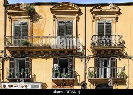 Facciate e finestre ornate, sopra i negozi, Agrigento, Sicilia, Italia Foto Stock