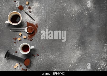 Composizione con tazze di caffè caldo e polvere di caffè su sfondo grunge grigio Foto Stock