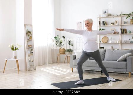 Sport sul pensionamento. Donna anziana attiva che fa l'allenamento dei Pilates a casa Foto Stock