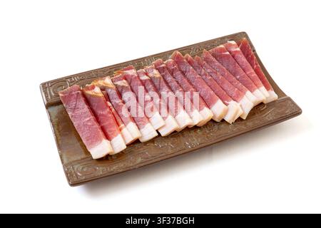 Fetta sottile di pancetta stagionata disposta per la cottura Foto Stock