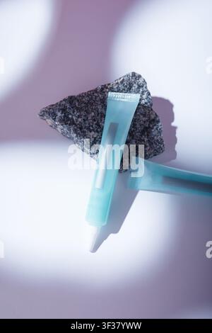 Modello di tubo blu vuoto, cosmetici per la cura senza marca, senza etichetta, contenitore vuoto su tavolo bianco sotto luce dura. Maschera per capelli, riempitivo, crema Foto Stock