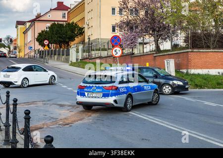 Auto di pattuglia della polizia che assicura la scena di un incidente stradale a un incrocio a Łańcut, Polonia Foto Stock