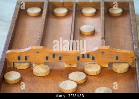 Gameplay di sjoelen, classico gioco da tavolo olandese con dischi di legno e tavola chiamata sjoelbak Foto Stock
