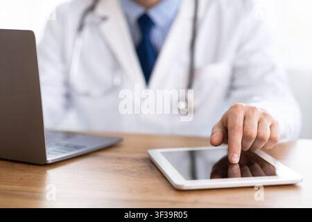 Primo piano del medico che usa il tablet digitale Foto Stock