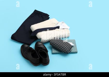 Abiti casual da lavoro ordinatamente piegati con accessori su sfondo blu Foto Stock