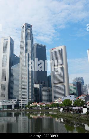 Riflesso dello skyline dei grattacieli moderni del distretto finanziario del fiume di Singapore sull'acqua blu e calma Foto Stock