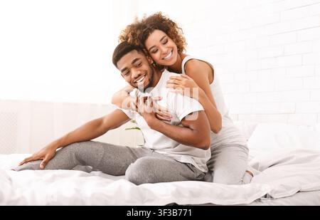Coppia felice flirting nella mattina sul letto confortevole Foto Stock