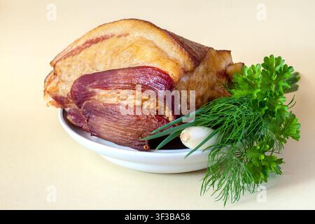 Lardo affumicato su un piatto. Un grosso pezzo di lardo con verdure. Foto Stock