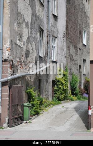 Passaggio stretto del cortile tra case popolari vecchie e consumate a Przemysl, nel sud-est della Polonia Foto Stock