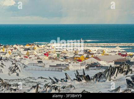 Berlevåg, Norvegia - 30.03.2019: Vista panoramica su tetti innevati in un vivace villaggio di pescatori norvegese sul mare Foto Stock
