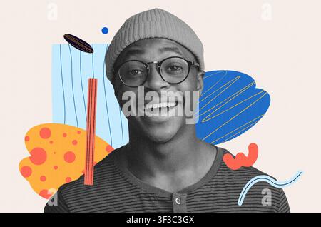 Giovane uomo afroamericano sorridente con occhiali e beanie, sfondo creativo Foto Stock