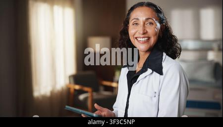 Medico, ritratto o medico in ospedale con tablet, servizio clinico o orgoglio come medico. Felice, tecnologia o donna matura con sicurezza, generale Foto Stock