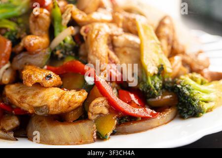 Prima piano di pollo alle mandorle Kung Pao, filetto di pollo saltato in padella alla thailandese, verdure, riso e mandorle, messa a fuoco selettiva, sfondo sfocato Foto Stock