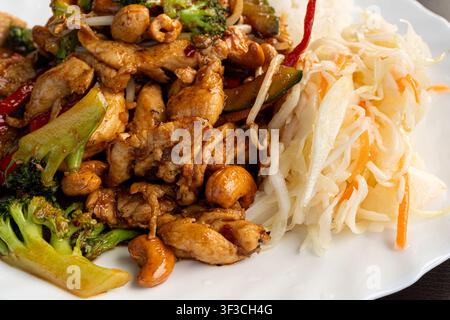 Prima piano di pollo alle mandorle Kung Pao, filetto di pollo saltato in padella alla thailandese, verdure, riso e mandorle, messa a fuoco selettiva, sfondo sfocato Foto Stock