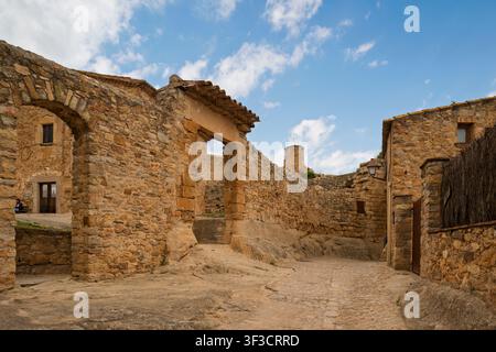 Strada stretta lastricata e arco in pietra antico nel villaggio medievale di Peratallada, Girona, Catalogna, Spagna, Europa. Foto Stock