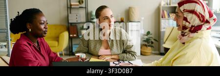 Donne diverse che collaborano in una riunione d'ufficio su una strategia inclusiva Foto Stock