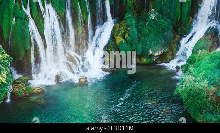 Vista ravvicinata di potenti cascate che sfociano in acque cristalline color smeraldo Foto Stock