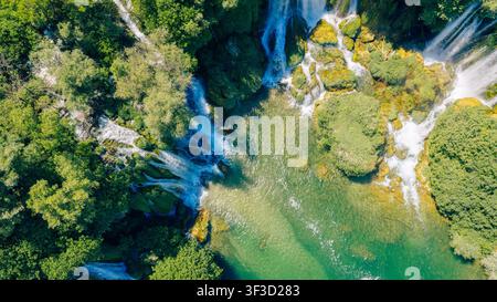 Vista aerea dall'alto di cascate che scorrono in piscine smeraldo Foto Stock