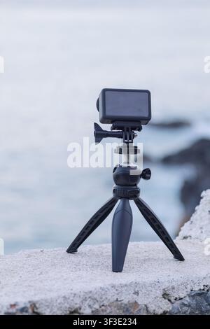 Fotocamera d'azione registra video su un treppiede in riva al mare Foto Stock
