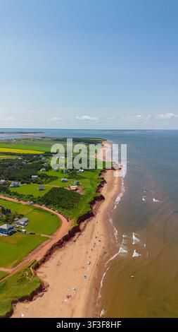 Veduta aerea della costa dell'Isola del Principe Edoardo, con spiagge di sabbia, scogliere di arenaria rossa, campi verdi e case nell'Isola del Principe Edoardo Foto Stock