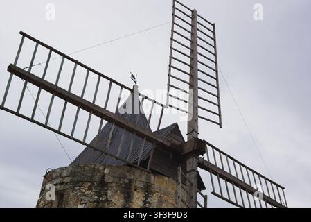 Primo piano delle pale in legno del mulino di Daudet (Moulin Saint-Pierre) sotto un cielo nuvoloso a Fontvieille, Provenza, Francia. Foto Stock