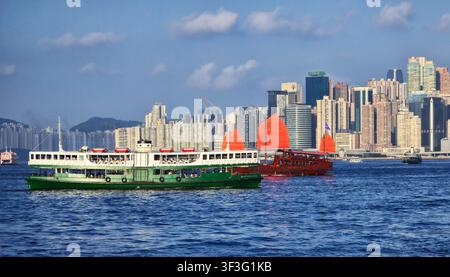 La Star Ferry e la giunca Aqualuna che navigano nel Victoria Harbour a Hong Kong. Foto Stock