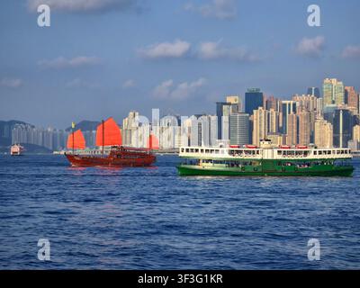 La Star Ferry e la giunca Aqualuna che navigano nel Victoria Harbour a Hong Kong. Foto Stock