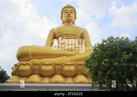 enorme statua dorata di Buddha seduta al Wat Paknam a Bangkok, Thailandia Foto Stock