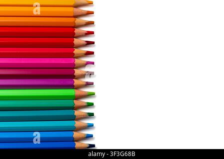 Matite di legno colorate disposte in uno spettro arcobaleno su uno sfondo bianco con spazio per il testo. Arte, educazione, creatività, design, cartoleria Foto Stock