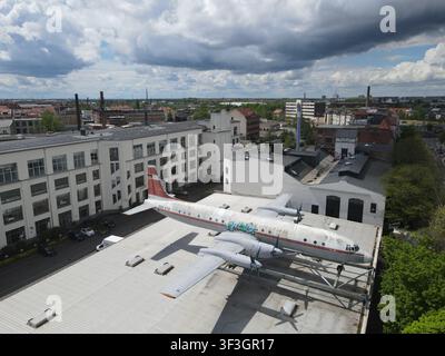Vista aerea di un aereo Ilyushin Il-18 montato sul tetto di un edificio industriale storico a Lipsia, Sassonia, Germania. Foto Stock