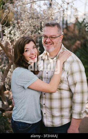 Una coppia affettuosa che sorride insieme in un giardino Foto Stock