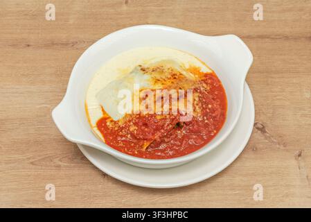 Cannelloni di pasta cotti al forno, ricoperti di formaggio fuso e ricca salsa di pomodoro, metà ricoperti di besciamella Foto Stock