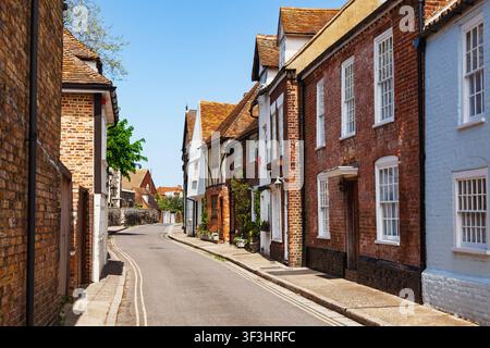 Case storiche costeggiano la dolcemente curva St Peter’s Street nel centro di Sandwich, Kent, Inghilterra Foto Stock