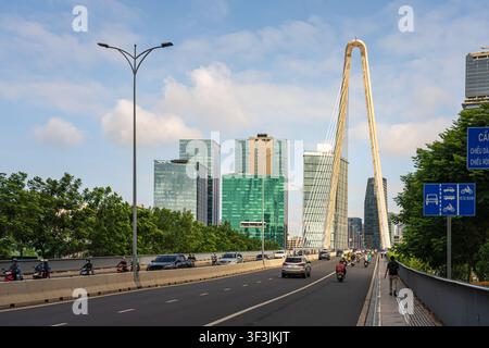 Il moderno ponte Ba Son si estende sul fiume Saigon accanto al distretto urbano di Thu Thiem, con traffico, grattacieli e cielo azzurro a Ho Chi Minh City, Vietnam. Foto Stock