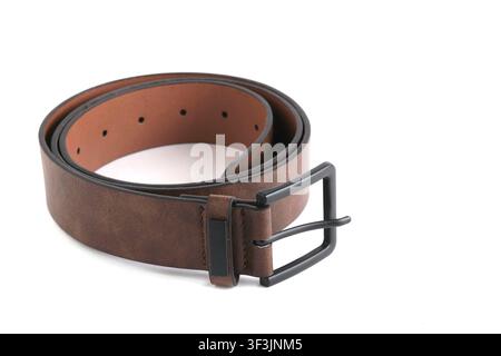 Cintura di pelle marrone arrotolata con fibbia nera opaca isolata su sfondo bianco pulito Foto Stock