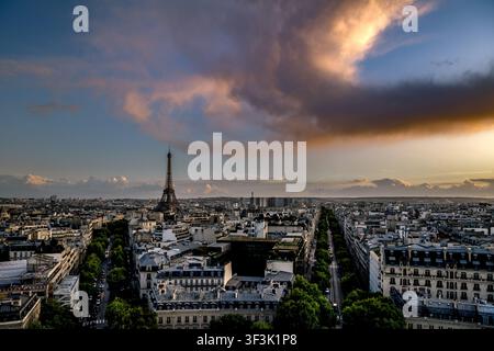L'iconica Torre Eiffel si erge sopra lo sconfinato skyline parigino in una vista drammatica al crepuscolo dall'Arco di Trionfo, con viali autunnali e edificio Foto Stock