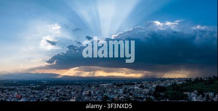 Le nuvole tempestose si aprono al tramonto sulla skyline di Città del Messico, Iztapalapa Foto Stock