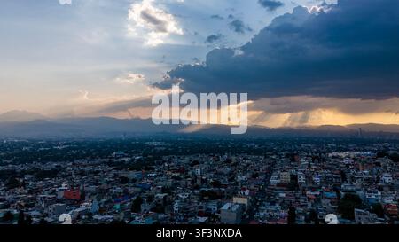 Le nuvole tempestose si aprono al tramonto sulla skyline di Città del Messico, Iztapalapa Foto Stock