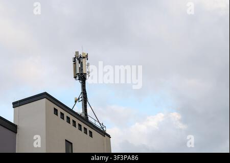 Torre di comunicazione cellulare con più antenne su un tetto. Foto Stock