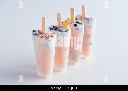 Popsicle di yogurt con frutti di bosco e fiori Foto Stock