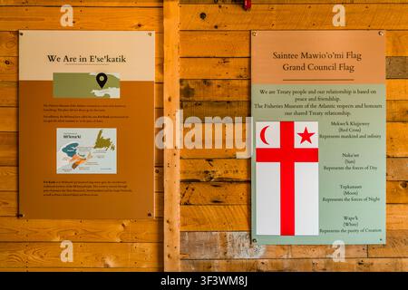 Pannelli informativi sulla regione Mi'kmaq di E'se'katik e sulla bandiera del Grande Consiglio, Saintee Mawio'omi, sono in mostra al Fisheries Museum of the Atlantic nella Città Vecchia di Lunenburg, Nova Scotia. I pannelli spiegano che Lunenburg si trova all'interno del territorio tradizionale Mi’kmaq e collegano il simbolismo della bandiera (la croce, la luna e il sole) ai valori fondamentali del rapporto di trattato tra i Mi’kmaq e i coloni. Lunenburg, Nova Scotia, Canada Foto Stock