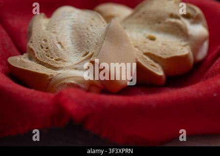 Panino artigianale appena sfornato che riposa in un cesto intrecciato rustico Foto Stock