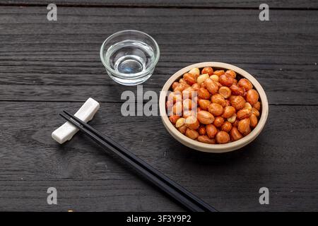 Mandorle gialle fritte servite in una piccola ciotola di ceramica Foto Stock