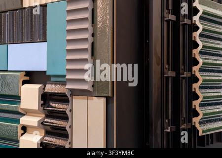 Campioni assortiti di profilati per rivestimenti e piastrelle con colori turchesi beige e neri, primo piano di un catalogo di materiali da costruzione Foto Stock