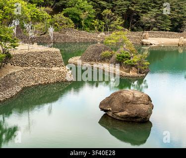 Isole del giardino di pietra riflesse in uno stagno calmo Foto Stock