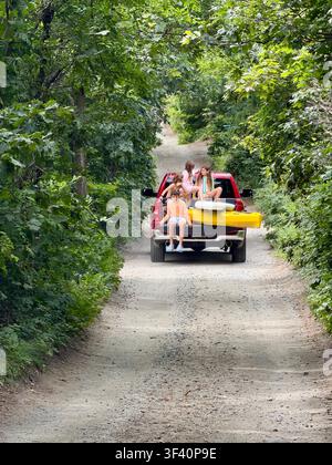 Bambini che viaggiano sul retro di un pickup in estate su una strada sterrata a Orleans, Cape Cod, Massachusetts. Foto Stock