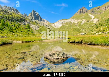 Alpe Campolungo, Svizzera – Ruscello di montagna cristallino e picchi frastagliati nella valle di Leventina, Canton Ticino. Foto Stock